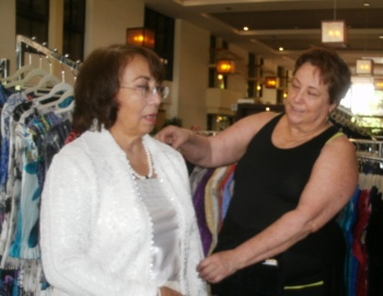 Bessie Hironimus trying on coat at vendor Pauline's stand