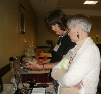 CFBPW President Katherine Winans looking at vendor Helen Crisp's jewelry